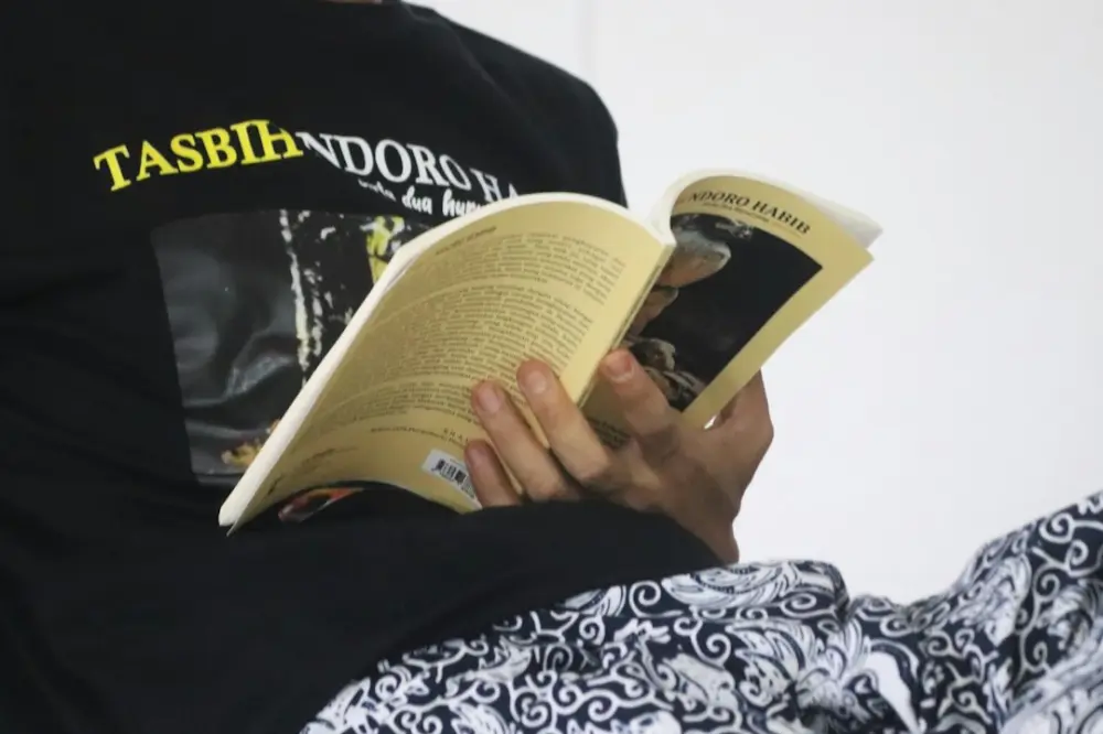 Person reading book on black and white textile, illustrating reading and new formats